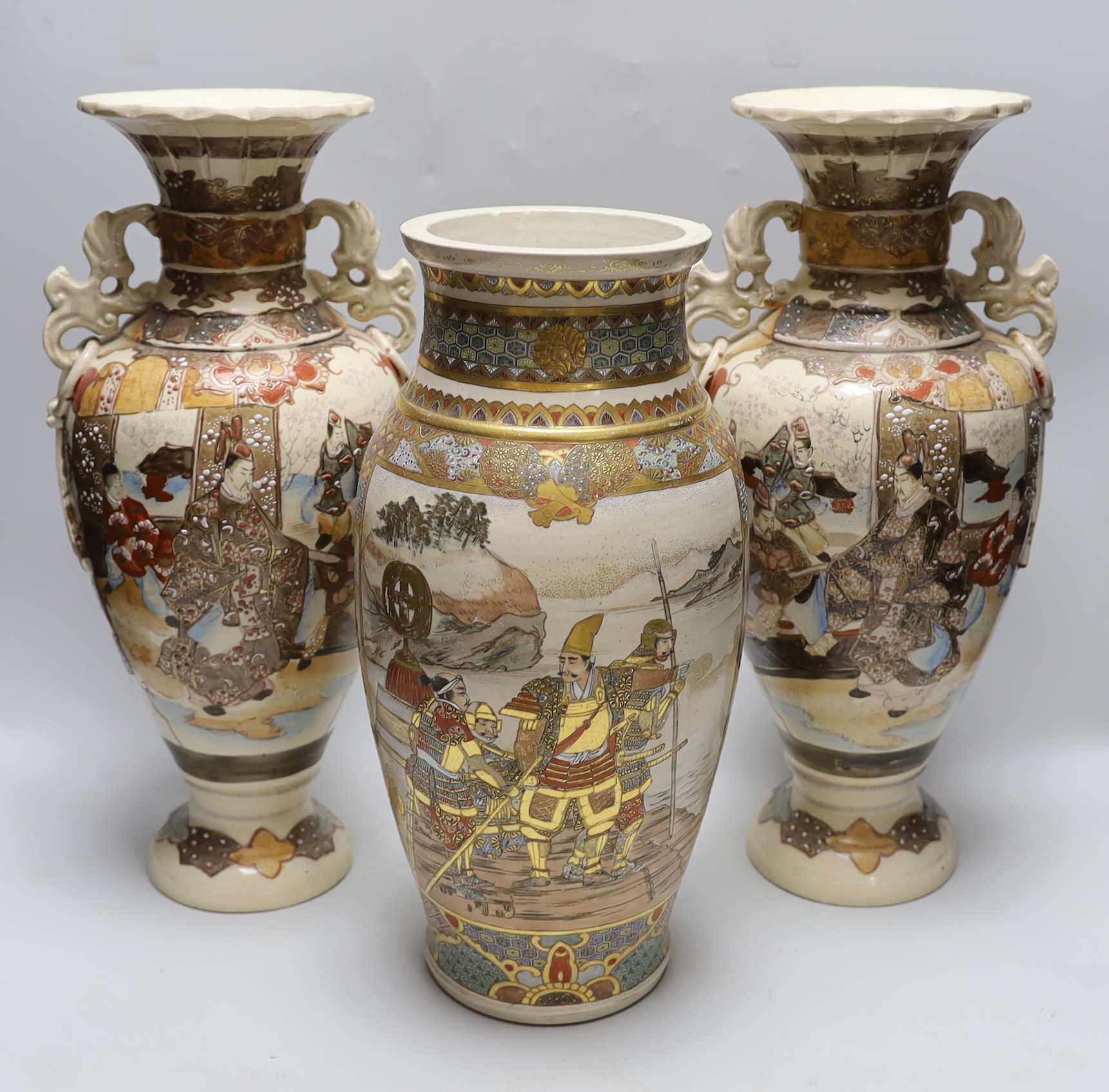 A pair of late 19th century Japanese Satsuma vases and a similar example, the largest each 42cm high (3)